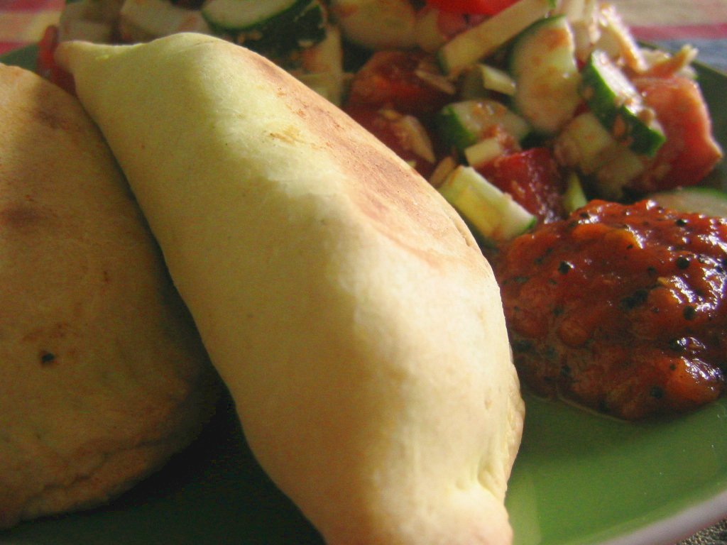 a taco, salad, and some bread on a plate