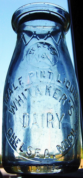 an old dairy jar with a little bit of dirt in it