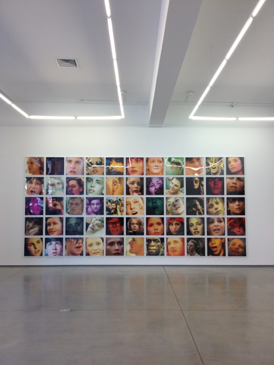 an installation in the center of a gallery of pictures on the wall and ceiling