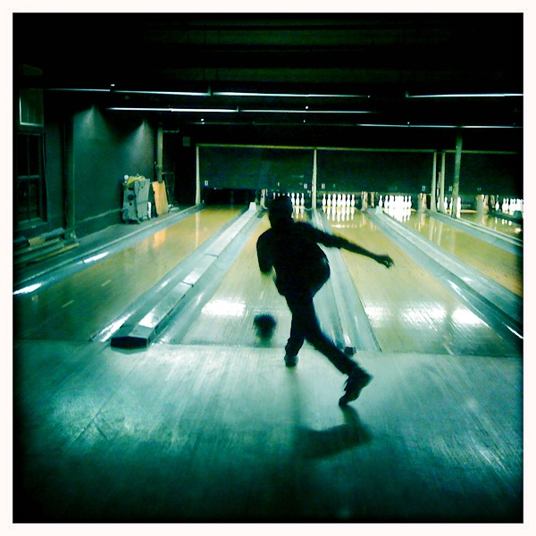 a man riding a skateboard on top of a bowling alley