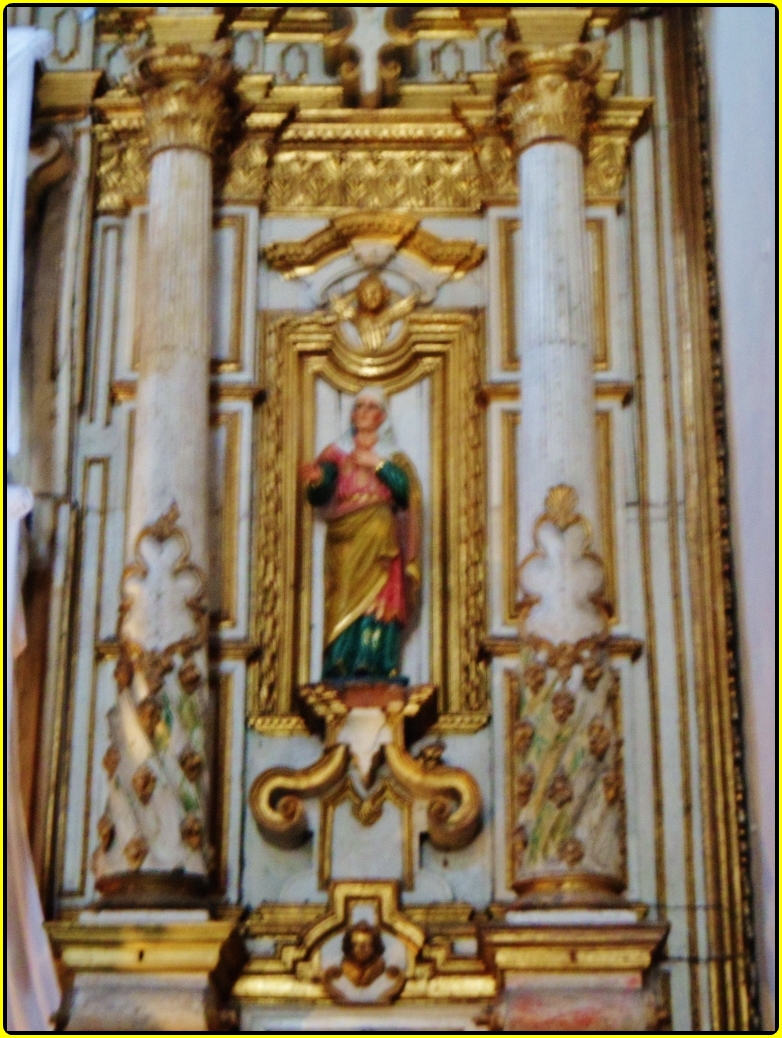an ornately painted gold church decoration with a statue