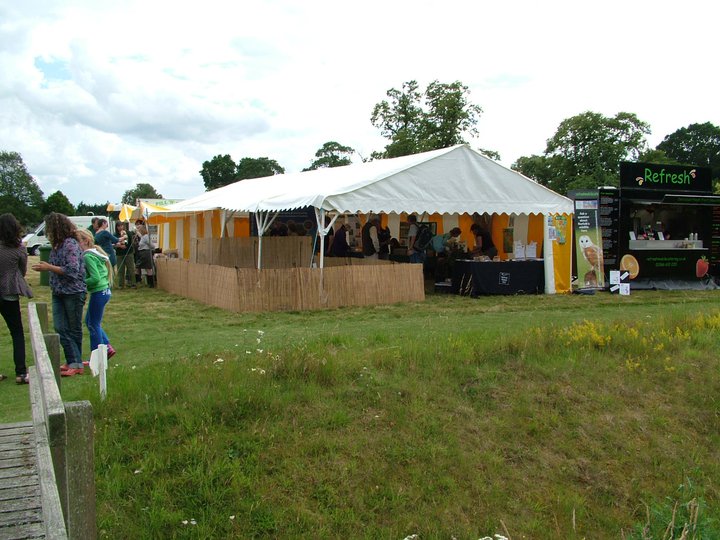 people stand in line for an event under a tent