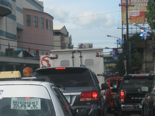 cars stopped at the red light on a crowded street
