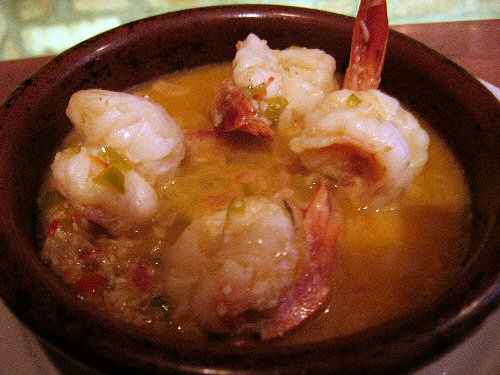 a close up of soup with shrimp and vegetables in it