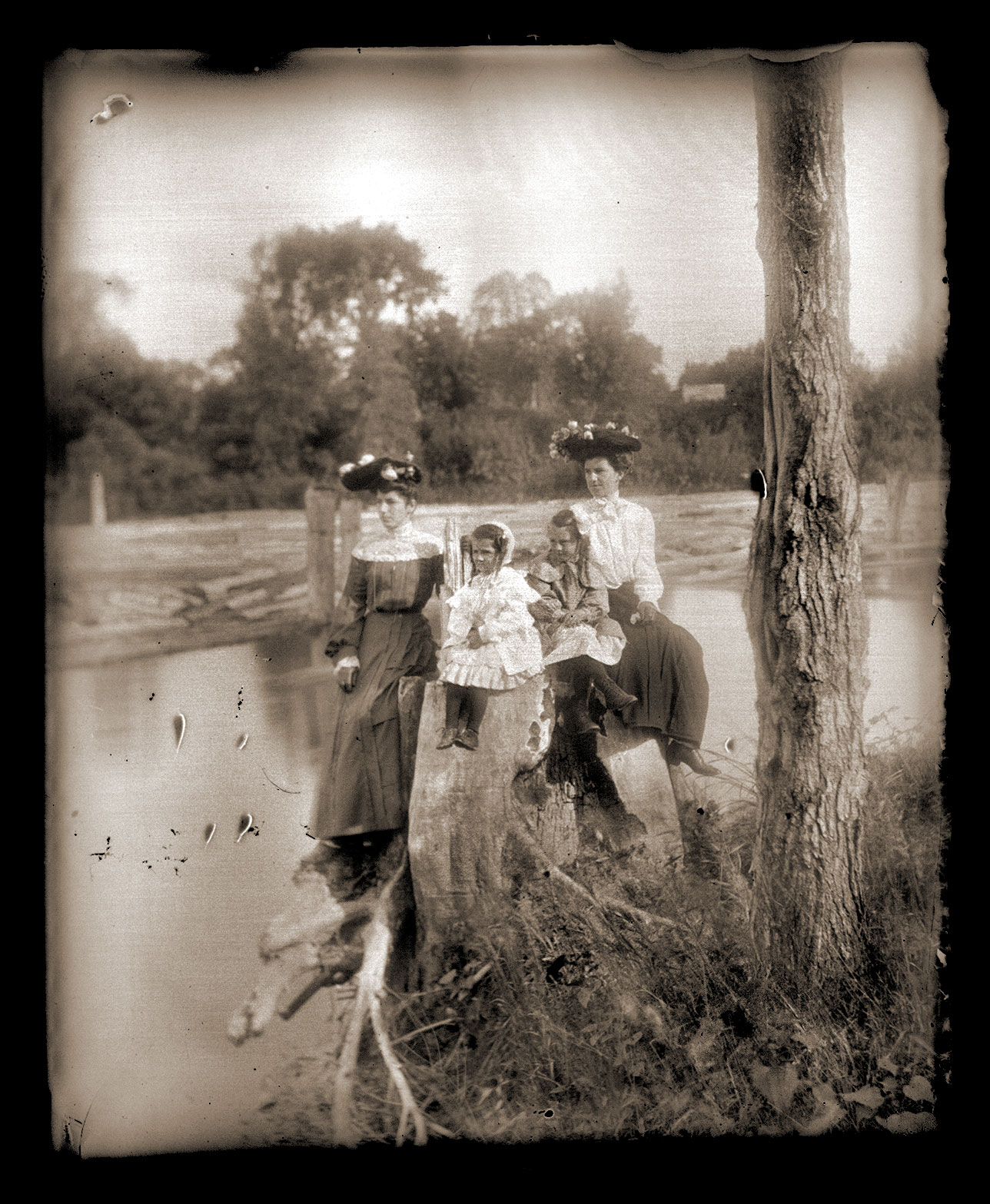 four women are posing for the camera while standing near a river