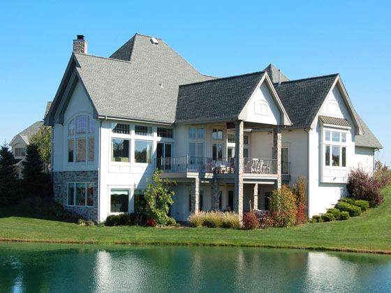 a view of a mansion overlooking a pond