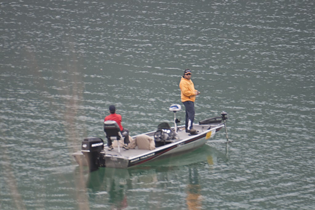 a man in a yellow coat standing on a boat