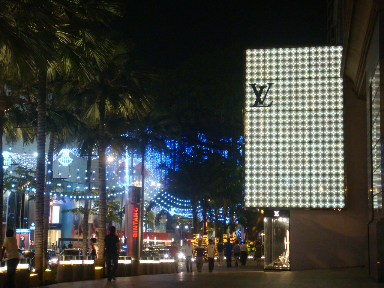 a large sign is in the middle of a city at night