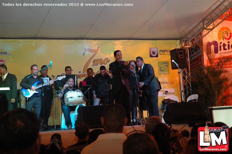 group of men standing on stage singing together