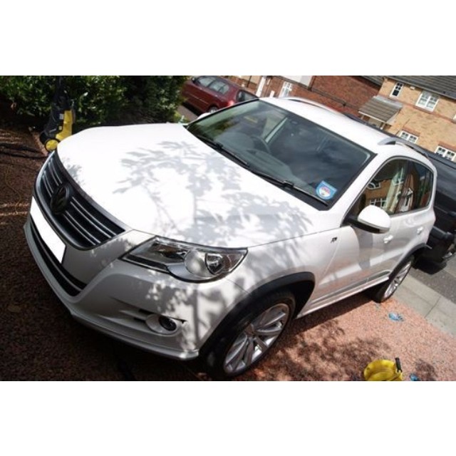 an image of a white car parked in the street