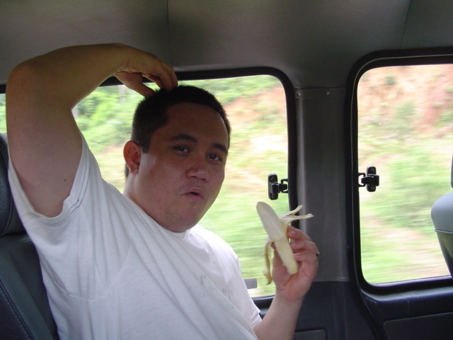 a man eating a piece of fruit in his car