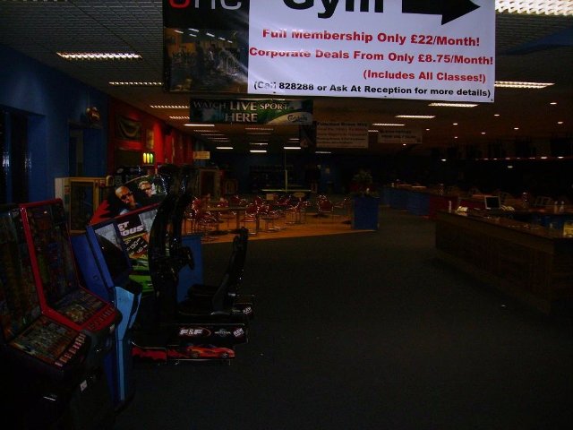 a large gym with a sign and rows of equipment on display