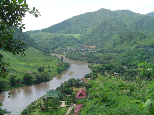 lush green hills surround a river in the middle of a forest