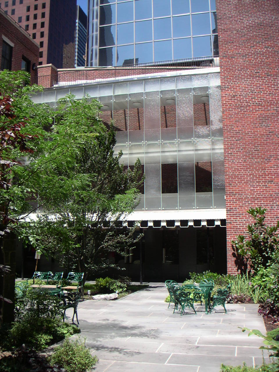 a brick building with several green chairs sitting outside