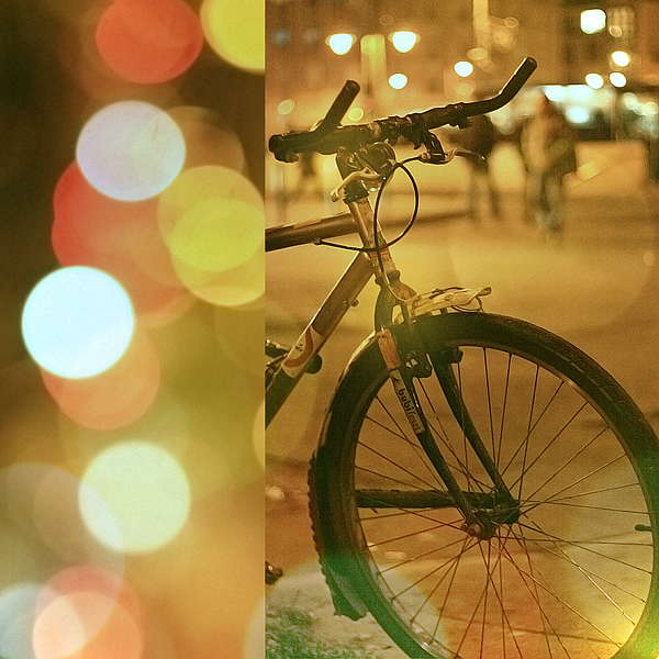 a po of a bicycle parked next to a street with bright lights