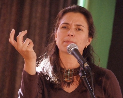 a woman giving a speech in front of a microphone