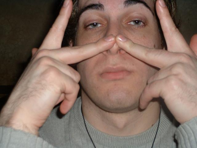 a young man making a silly face while holding hands in front of his eye