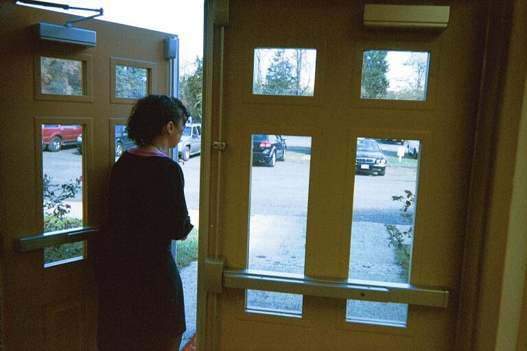 a woman entering a door with double windows