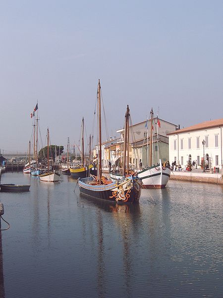 several boats are parked in the water by buildings