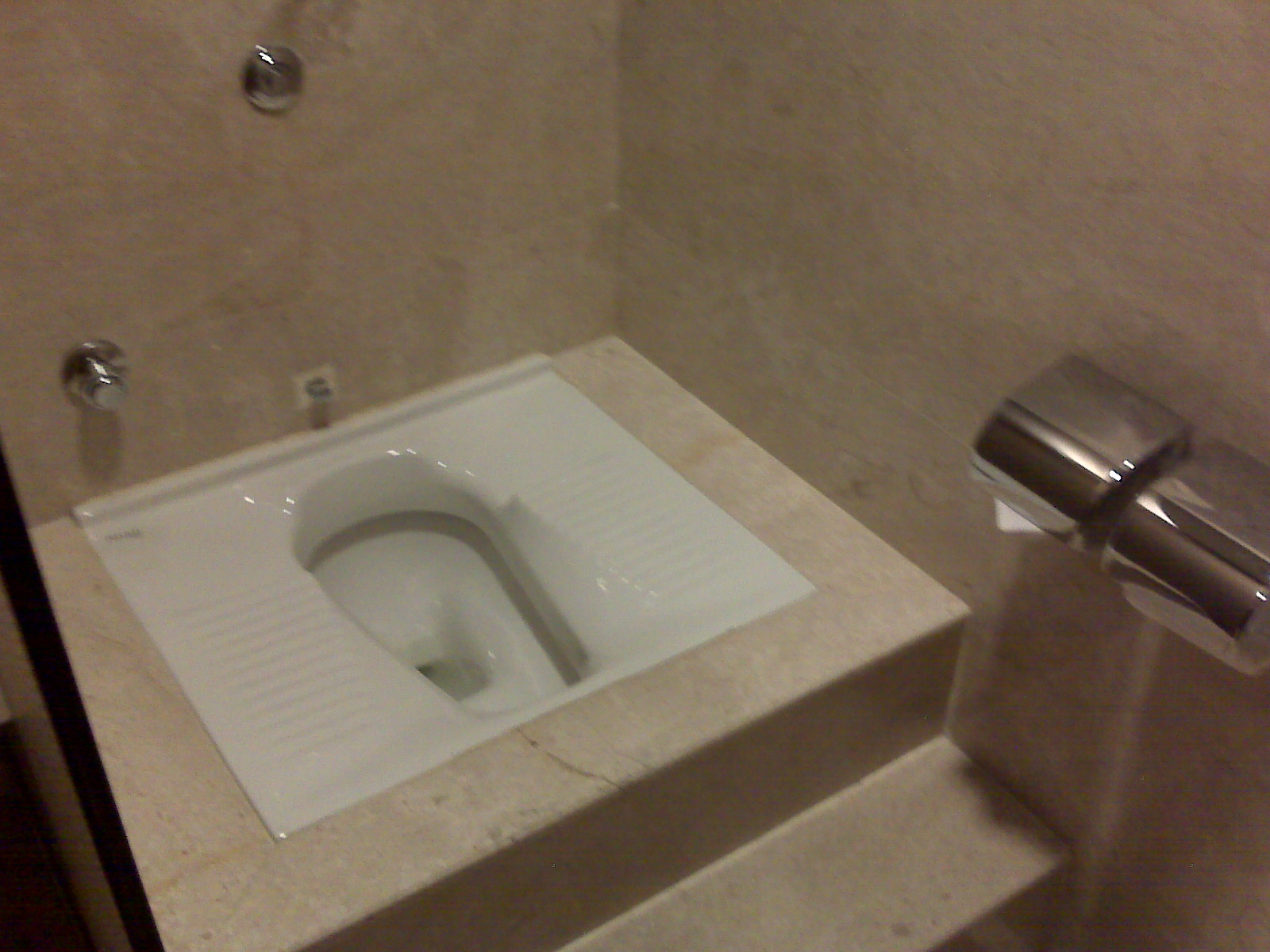 a white toilet sitting inside of a bathroom stall