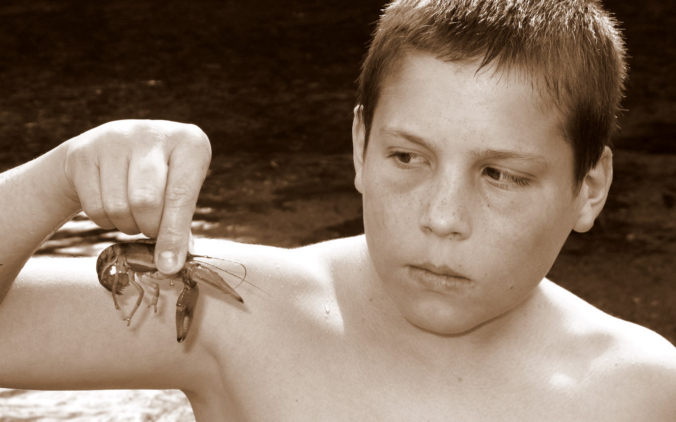 boy posing with shrimp on arm in sepia tone