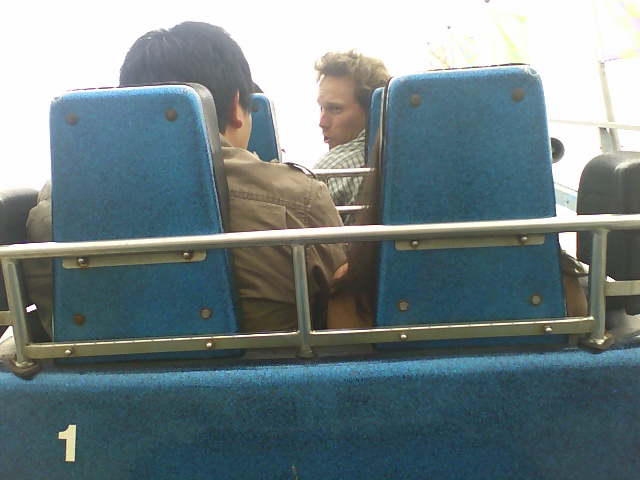 two people are on the bus with a cell phone to their ear