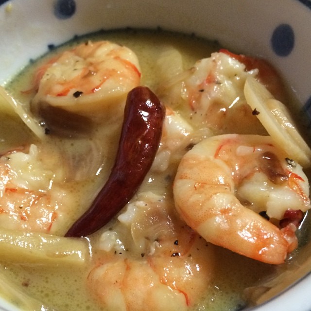 a bowl of shrimp and shrimp soup with a red  chili