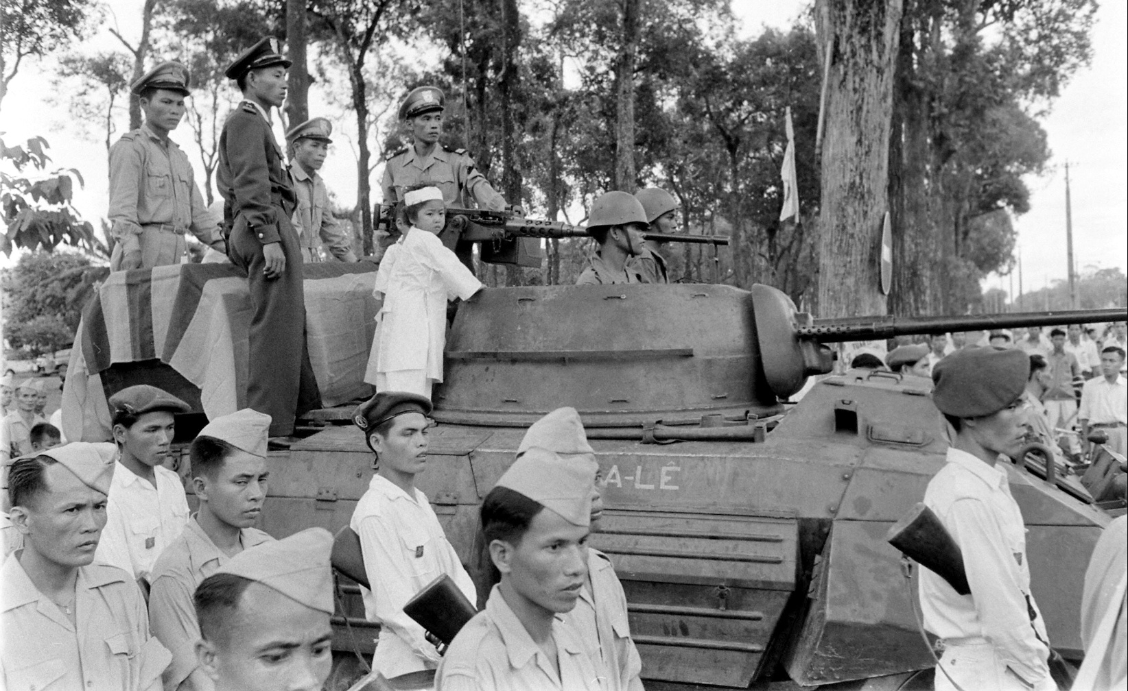 a group of men riding on the top of an army tank