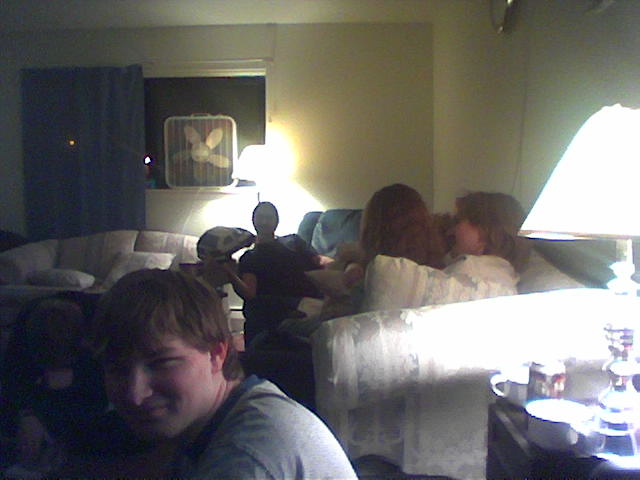 a bunch of people sitting and standing in the living room together