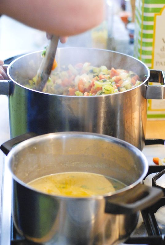 a woman stirring food in a pot on the stove