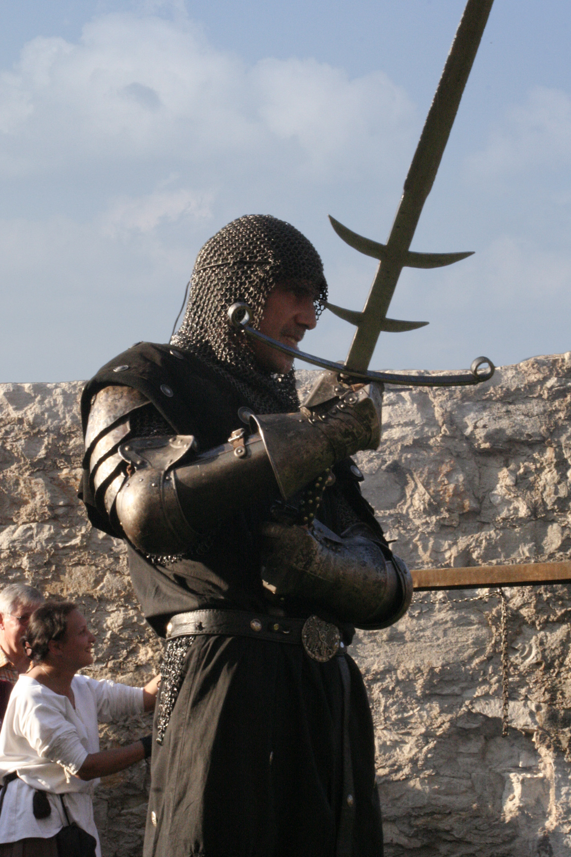 a person dressed in armor and holding a long sword