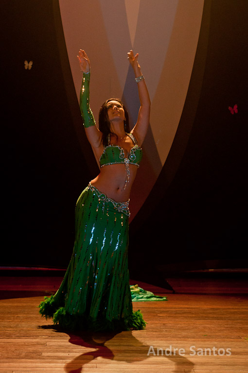 a woman in a green and sequined dress dances in a room