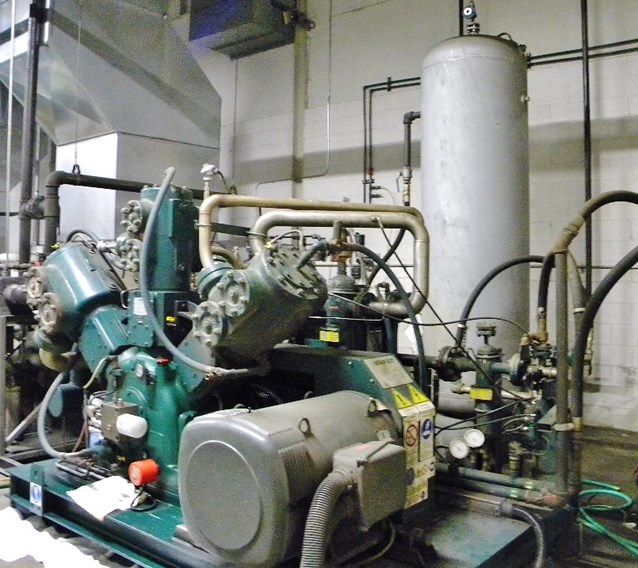 two industrial machines sitting in front of a wall