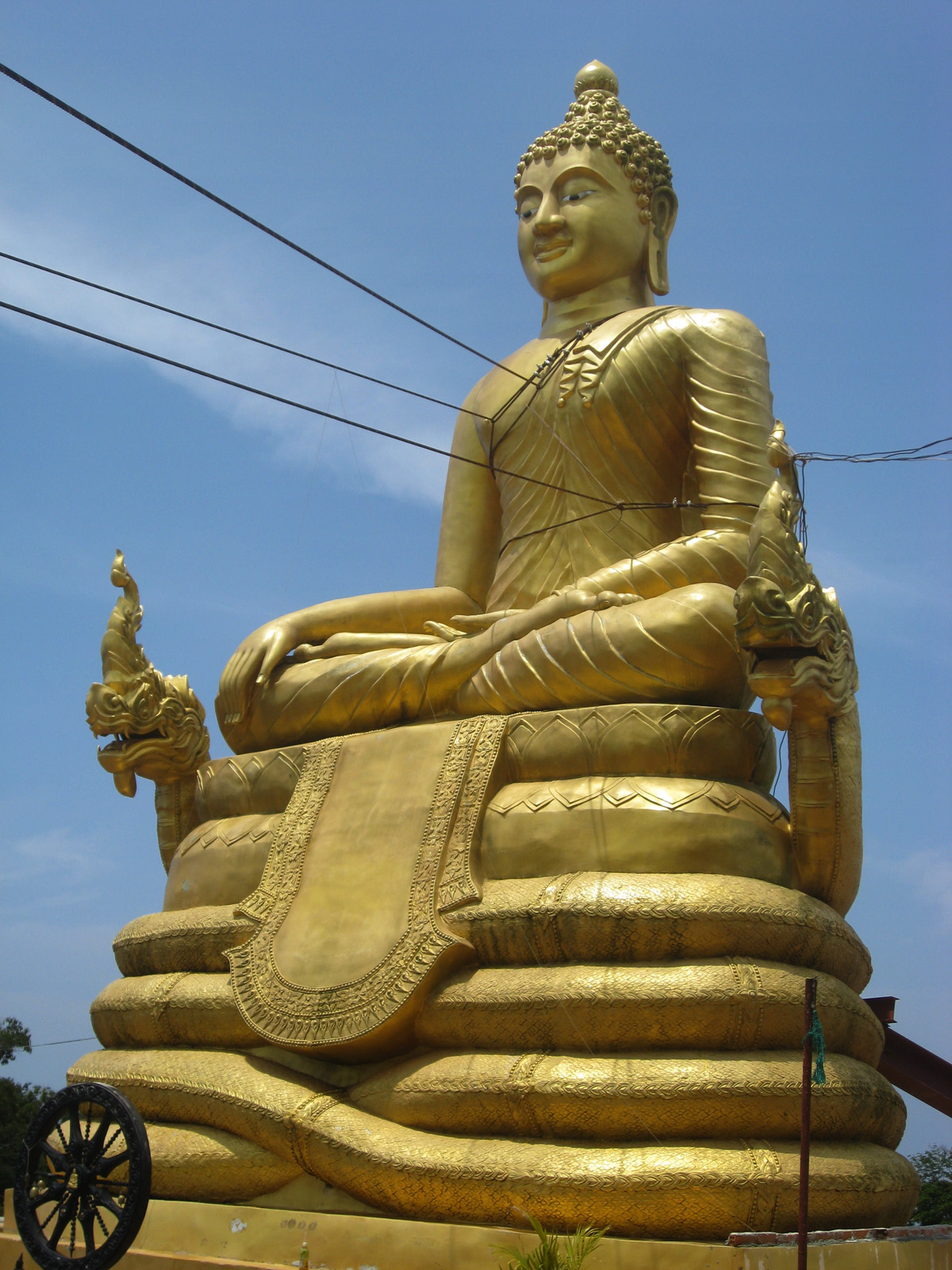 golden buddha statue sitting on an intricate gold base