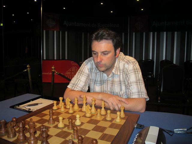 a man playing chess in front of a crowd