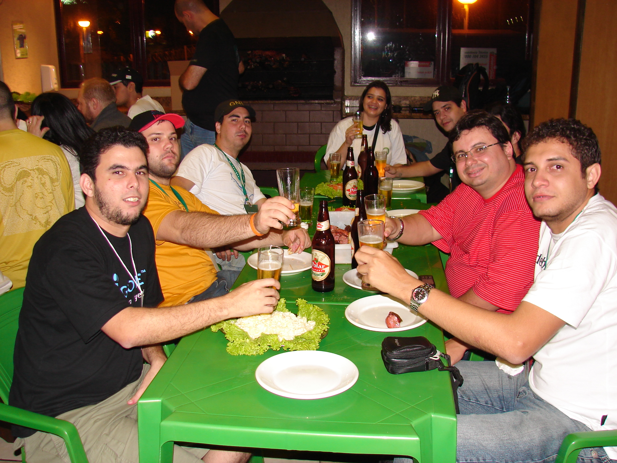 several men sitting at a table with beers and food