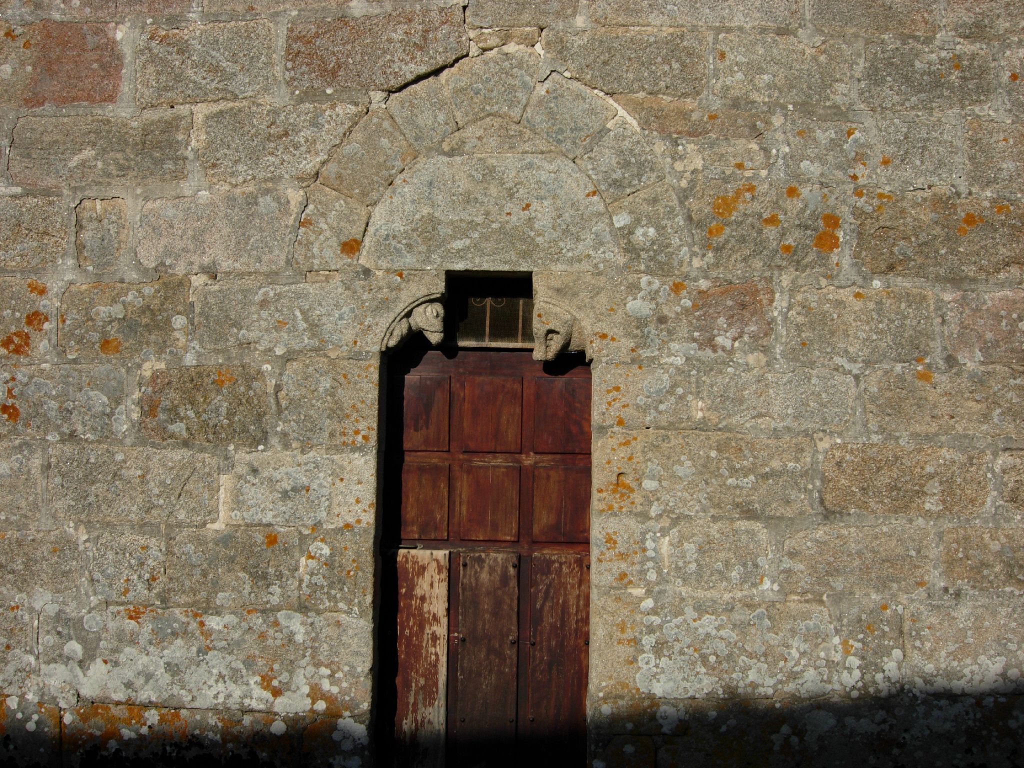 an old brick wall with a wooden door and window