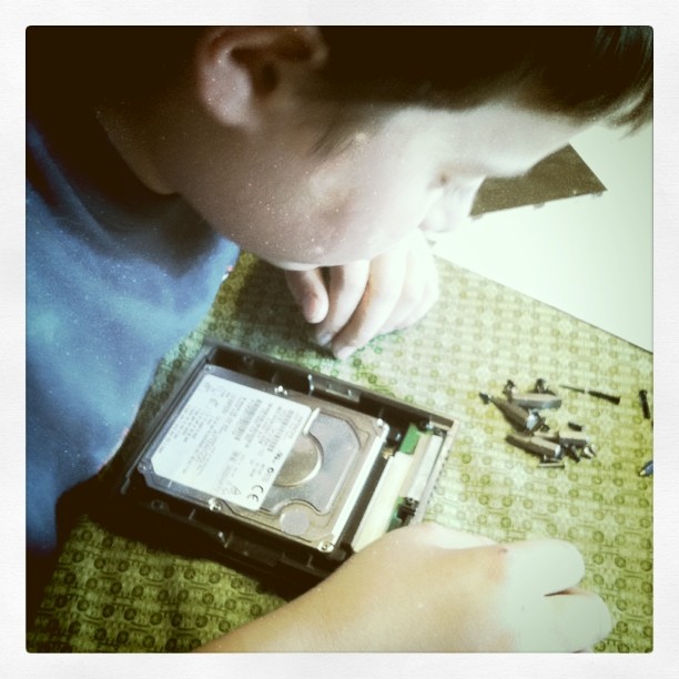 a boy who is looking at an old disk drive