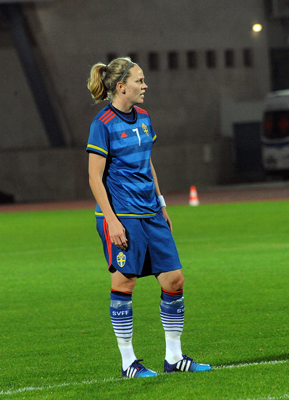 a female soccer player in the middle of a field