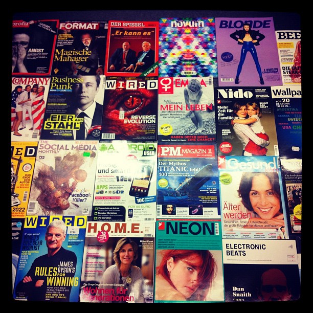 a very big pile of magazines on the table