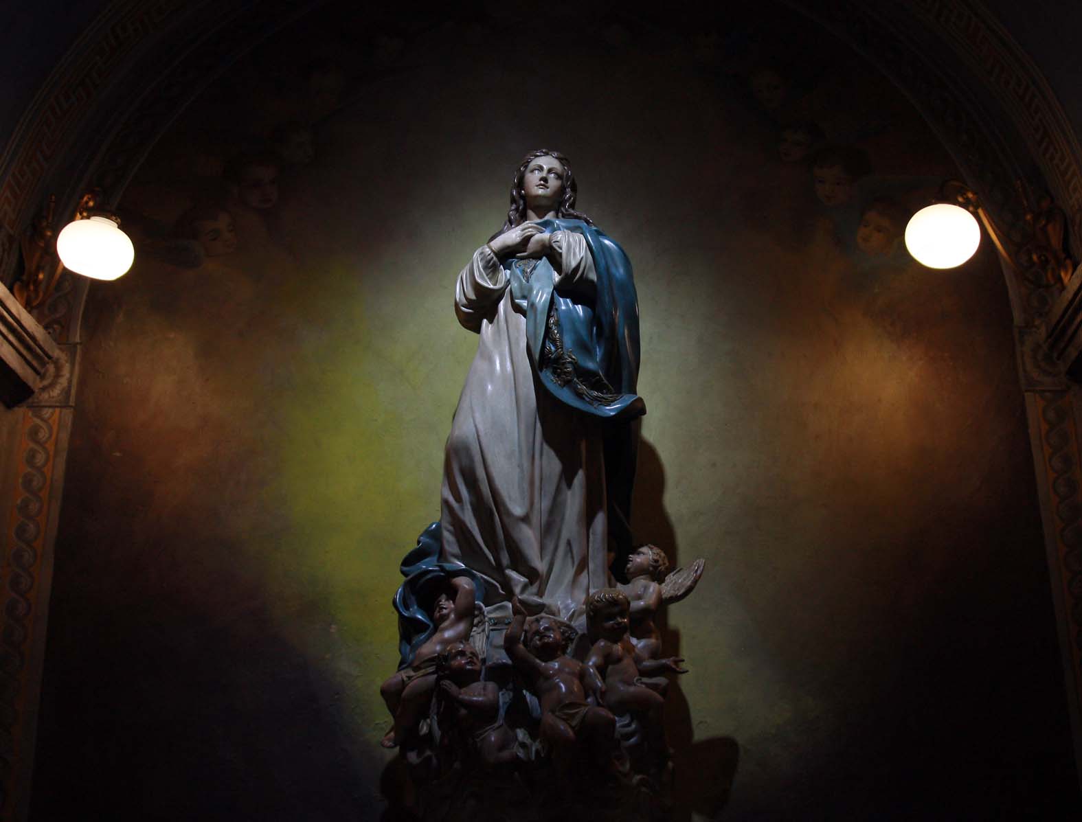 the statue of mary is shown in front of two lights