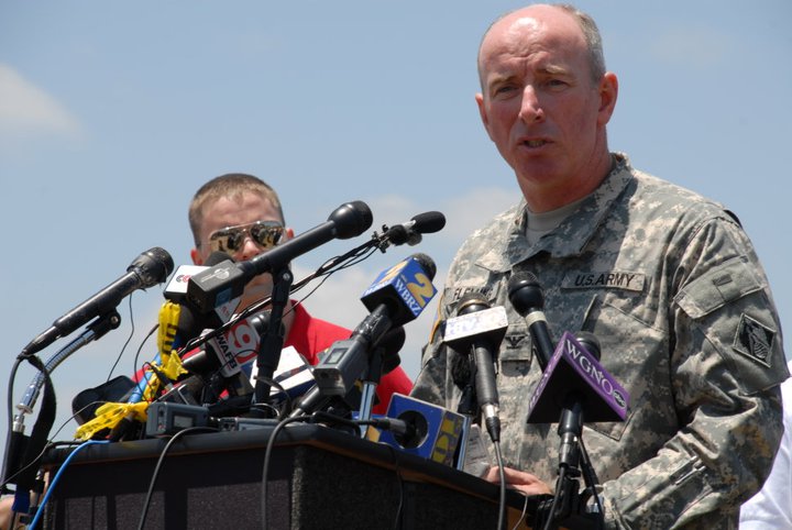 a man and woman in military uniform standing at microphones with an air force officer