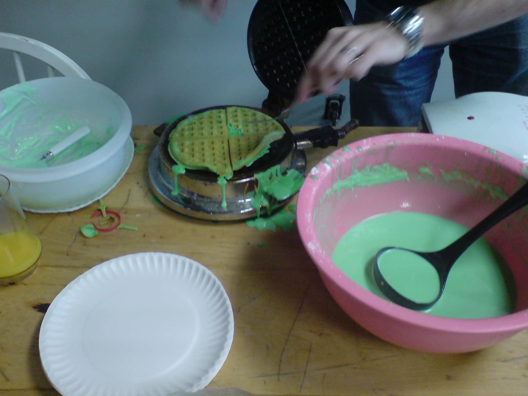 a pancake being put in a pink and green bowl