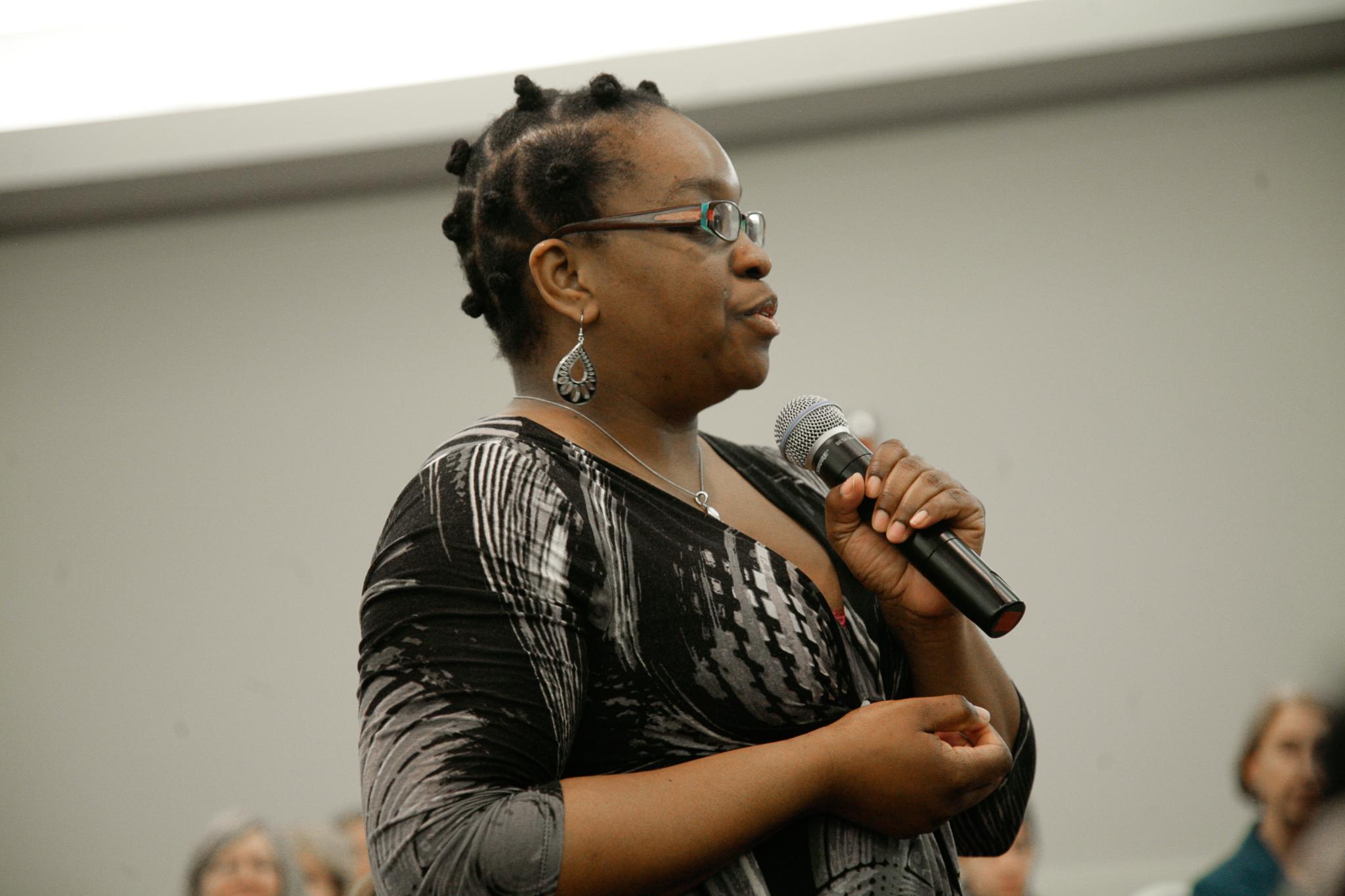 a woman with glasses is holding a microphone