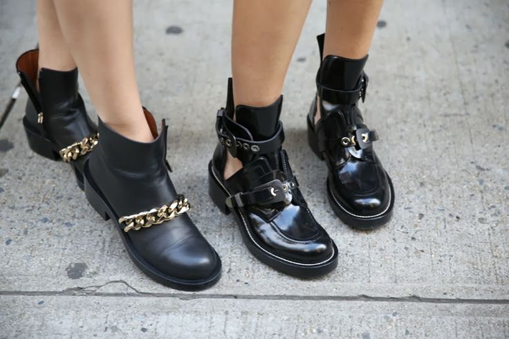 several pairs of black boots and chain accents on the ankles