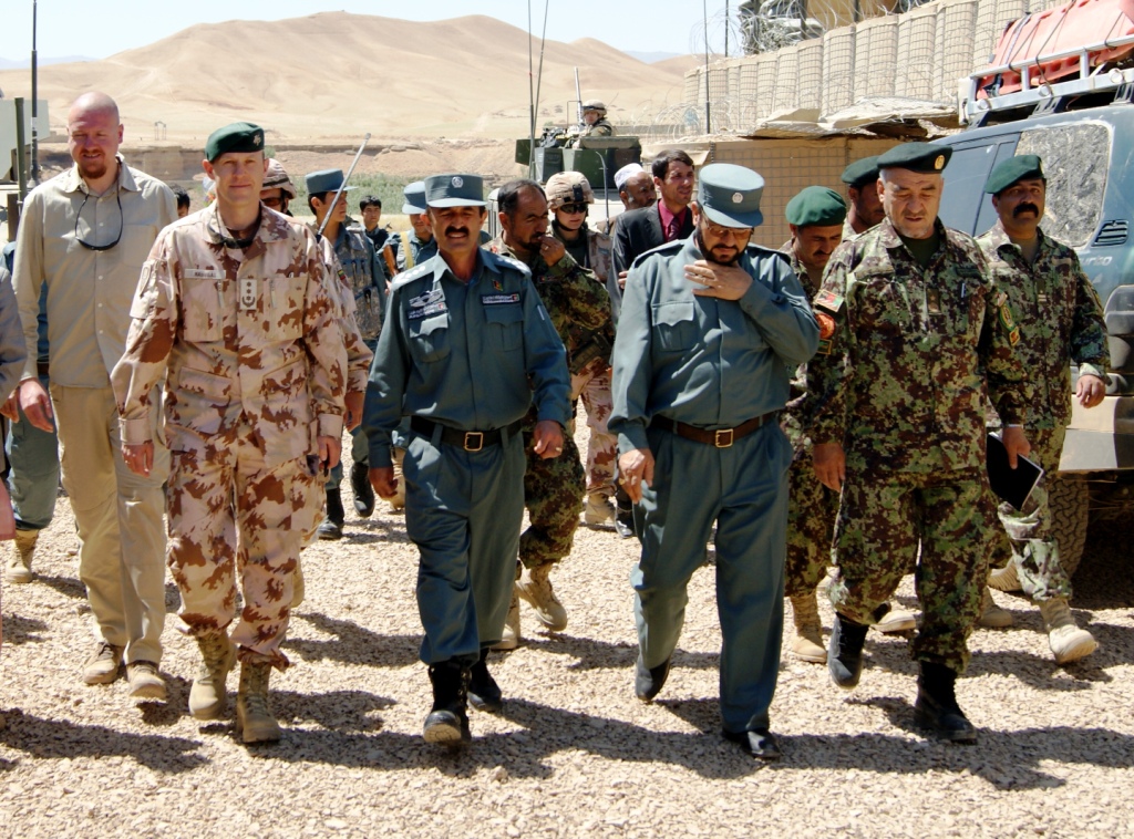 soldiers walking through desert near a group of military men