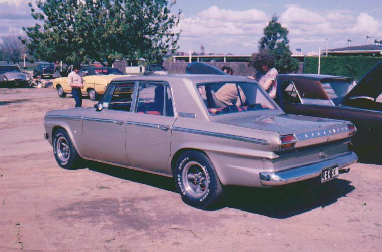 a grey car with a person in the driver seat