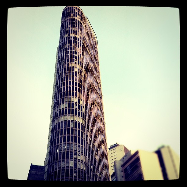 a tall tower in the city against a bright blue sky