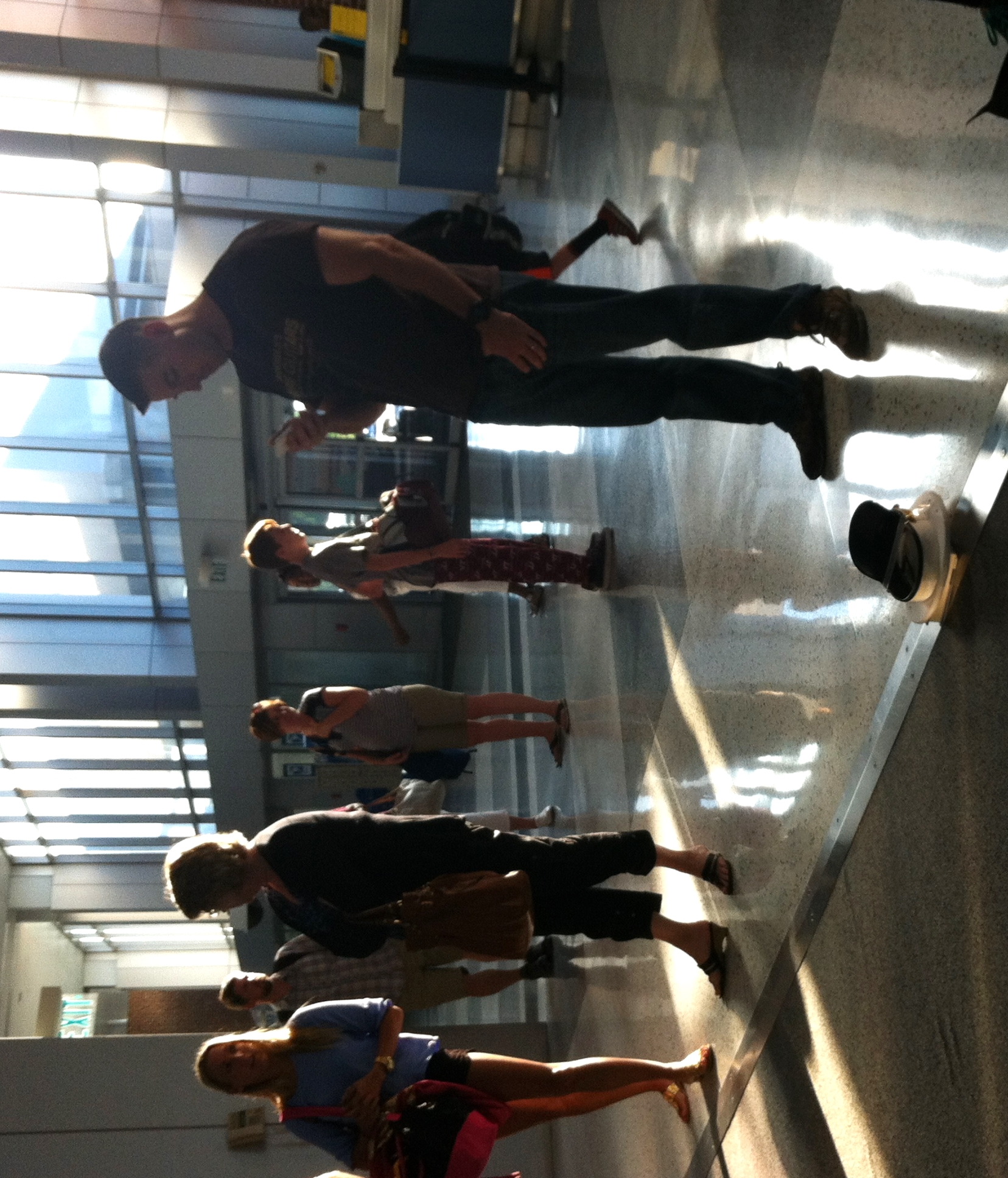 man in black shirt with his feet up on a skateboard in front of many people