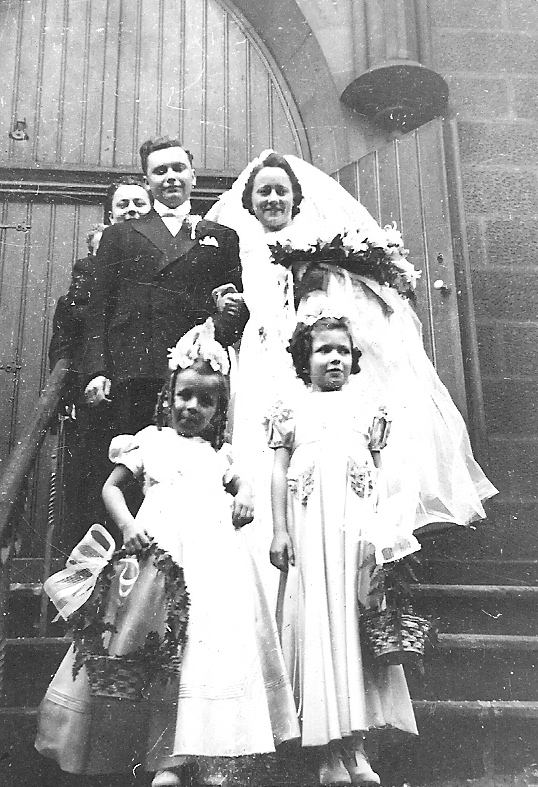 a couple and their wedding party standing in front of a building